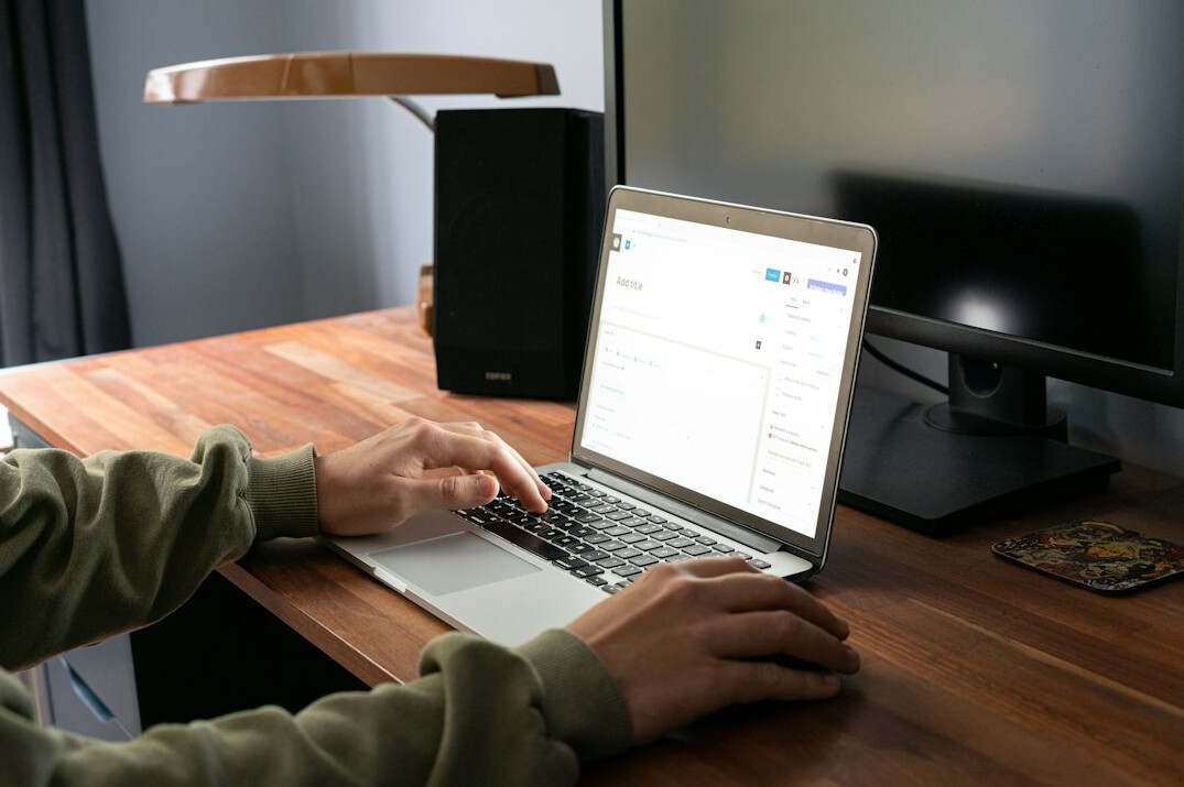 person coding on laptop at desk