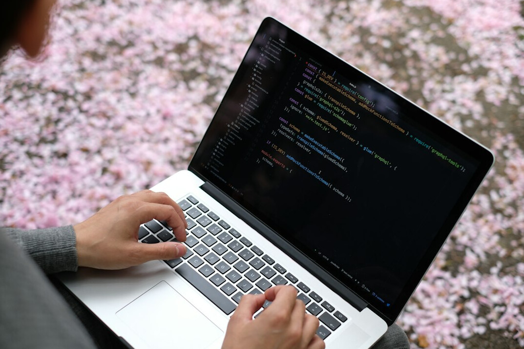 young person coding on laptop