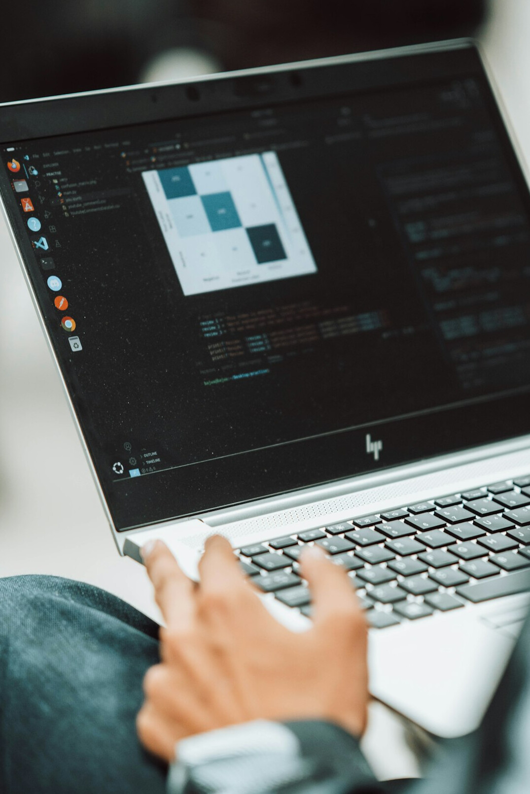 young person coding on laptop