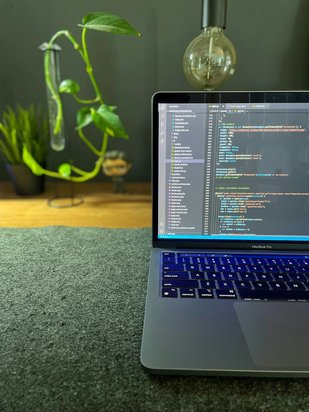 Open laptop displaying code on a wooden desk with a coffee cup